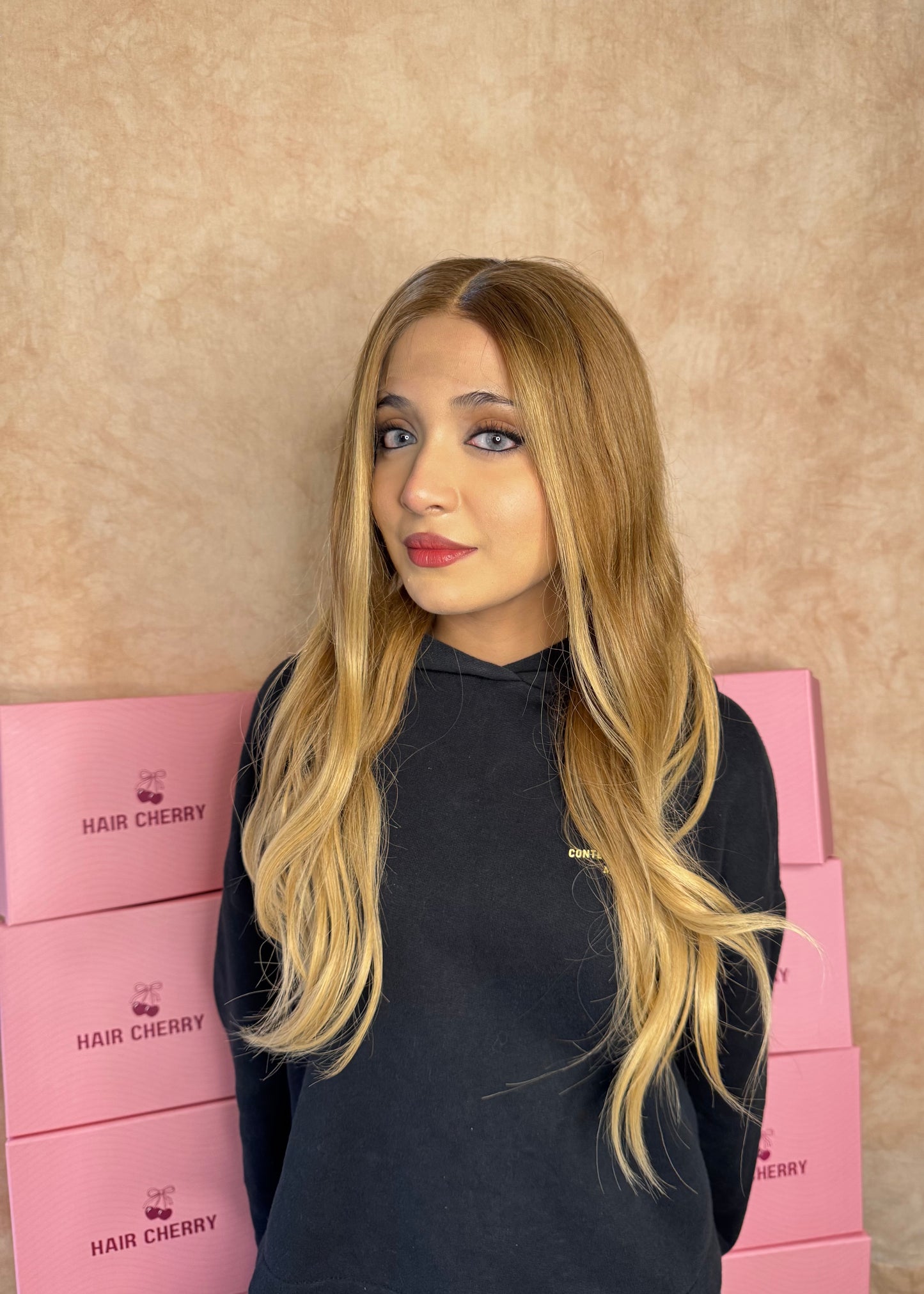 Woman wearing a 100% human hair caramel blonde wig with a realistic natural hairline, styled for a soft and effortless look.